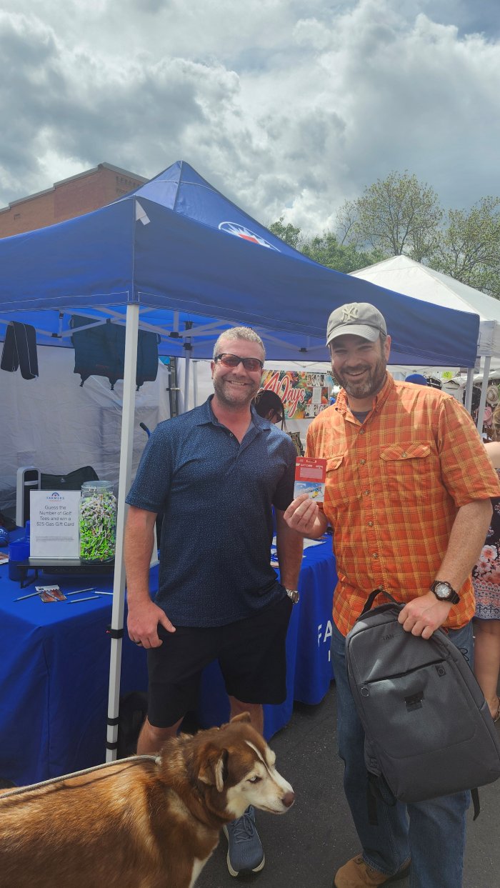 A community member winning a gas gift card at a Reardon Agency booth